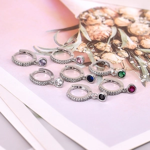 Macro shot of 925 silver hoop earrings with seven different colors of round zircon drops