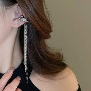 Silver winged horse ear cuff with star charms and long rhinestone tassels on model