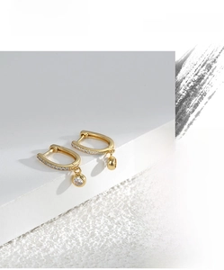 Close-up of gold-plated U-shaped earrings with micro-set zircon and single round drop pendant