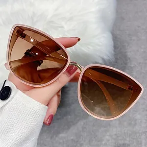 Pink cat-eye sunglasses with gradient lenses and gold metal bridge on plush background