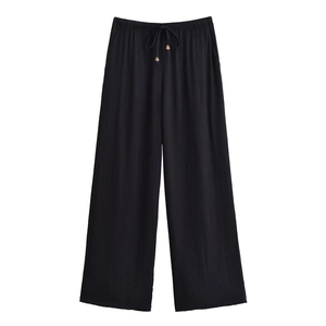 Detail der schwarzen weiten Hose mit elastischem Kordelzugbund und dekorativen Holzperlen