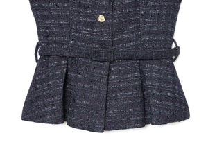 Détail du gilet en tweed avec bouton fleur dorée et ceinture de taille intégrée