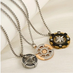 Detailed trio of compass star pendants in silver, gold, and black steel on cloth