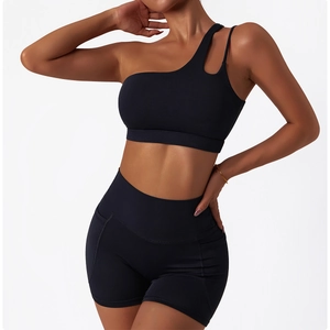 Detail of black one-shoulder sports bra with stylish cutout and high-waisted gym shorts