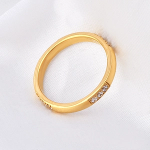 Polished 18K gold plated titanium steel ring with twelve inlaid zircons on white fabric