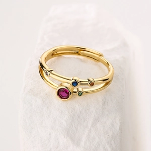 Detail of double-layer gold plated ring with colorful zircon stones on white stone