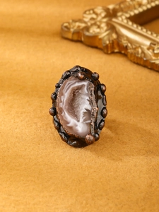 Macro shot of natural druzy agate ring with rustic bronze finish and crystal textures