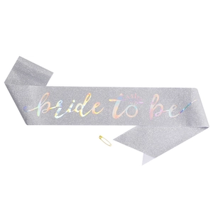 Detail of silver glitter Bride To Be sash with holographic text and gold safety pin