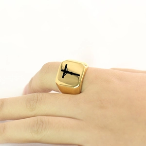 Polished gold stainless steel signet ring with black laser-engraved cross on finger