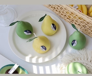 Detailed view of handmade pear-shaped scented candles in yellow and green wax