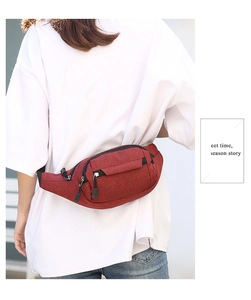 Rear view of a model wearing a dark red canvas waist bag for sports and travel