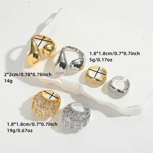 Minimalist gold and silver waterdrop rings with zircon stones on white stone slab