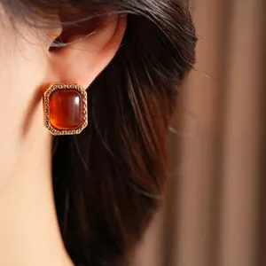 Vintage rectangular amber resin earrings with engraved gold metal frames on female model