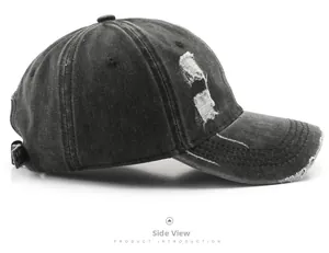 Detail view of vintage washed black denim baseball cap with distressed rip effects