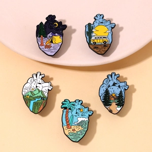 Detail view of five anatomical heart enamel pins featuring landscape and travel scenes