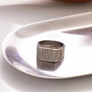 Macro view of men's silver signet ring with full pavé diamonds and polished metal finish