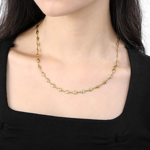 Golden heart-shaped chain necklace worn on neck showcasing metallic luster