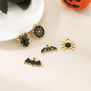 Detail of Halloween enamel charms featuring black spiders, bats, and web on spooky background