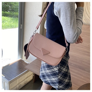 Vue détaillée du sac bandoulière en cuir grainé rose avec logo mode et crochets métalliques