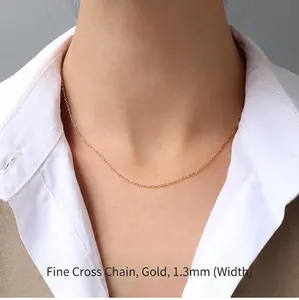 Close-up of 1.3mm gold-plated titanium cross chain necklace worn with a white shirt