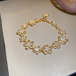 Close-up of golden hollow flower bracelet with sparkling white cubic zirconia stones