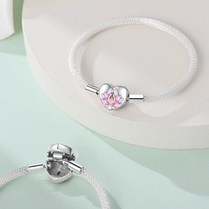 Detailed view of silver mesh bracelet featuring a pink lotus enamel heart clasp
