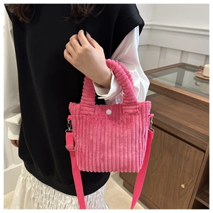 Detail of pink corduroy bucket bag texture with top handle and adjustable strap