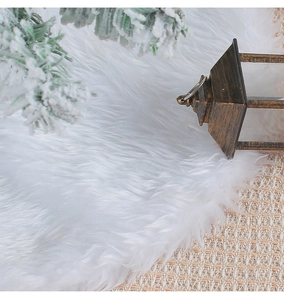 Detailed shot of white faux fur Christmas tree skirt with plush texture and pine decor