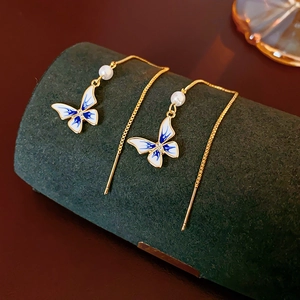 Detail of 14K gold plated butterfly earrings with blue enamel and white pearls