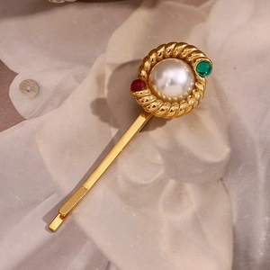 Detail of 18K gold plated twisted hair clip with white pearl and colored gems