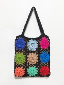 Detail showing colorful hand-crocheted floral squares on a black woven shoulder bag
