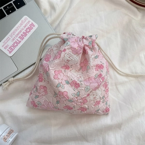 Detailed view of floral drawstring storage pouch in pink jacquard fabric with drawcord