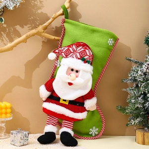 Close-up of green felt Christmas stocking with 3D Santa plush hanging on a branch