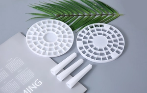 Disassembled white circular pen organizer components including grid plates and support pillars