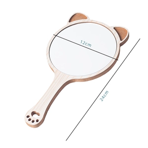 Detail view of a cat-ear wooden hand mirror measuring 12cm wide and 24cm long
