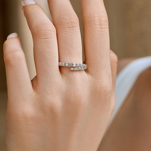 Detail of silver wrap ring with rectangular zirconia stones on woman's finger