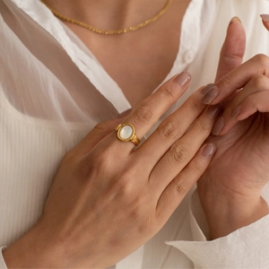 Elegant gold oval white mother of pearl ring worn on hand for a luxurious vintage look