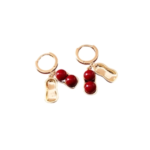 Elegant peanut-shaped gold-plated earrings featuring red beads on a clean white background