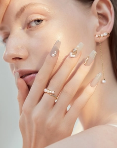 Makro-Detail von elegantem, vergoldetem Ring und Ohrringen mit Naturperlen