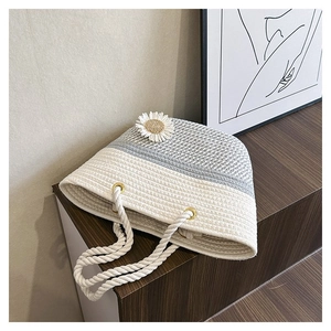 Close-up of handmade woven cotton rope tote bag with daisy ornament and rope handles