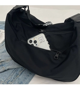 Detail view of the waterproof crossbody bag back pocket with a white smartphone