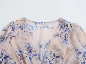 Détail du col en V d'une robe en mousseline fleurie avec étiquette de taille S visible