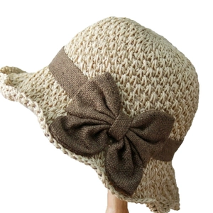 Summer straw sun hat in beige with dark brown woven band and a large decorative bow