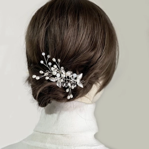 Elegant bridal hair vine with silver leaves and white pearls on a wedding hairstyle