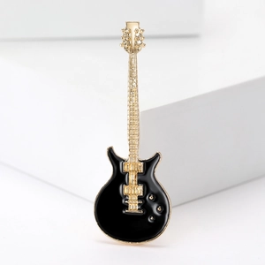 Detailed macro shot of a black and gold enamel electric guitar brooch pin accessory