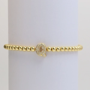 Detail of gold beaded bracelet featuring a micro-pave zircon letter Q bubble pendant