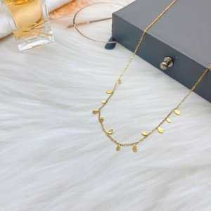 Elegant gold titanium steel teardrop necklace with oval sequins on plush background