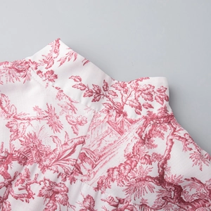 Détail de l'imprimé Toile de Jouy rouge et blanc sur le col et l'épaule d'une robe