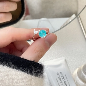 Macro shot of 925 sterling silver ring with blue gemstone and fishtail detail