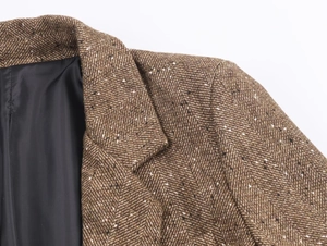 Gros plan du tissu blazer à chevrons marron avec couture d'épaule et doublure noire